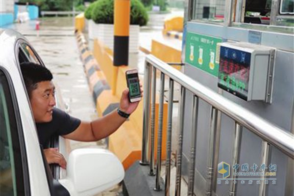 汽車(chē)駕駛員正在沈陽(yáng)高速公路收費站用手機掃碼支付通行費